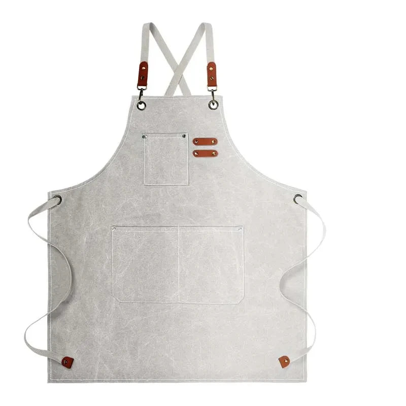 Waxed Canvas Barista Apron laid flat showing full front panel with leather straps and utility pockets